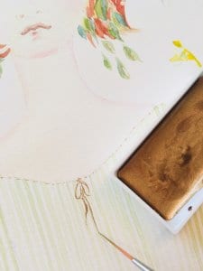 Man sieht das Malen mit einer goldenen Aquarellfarbe