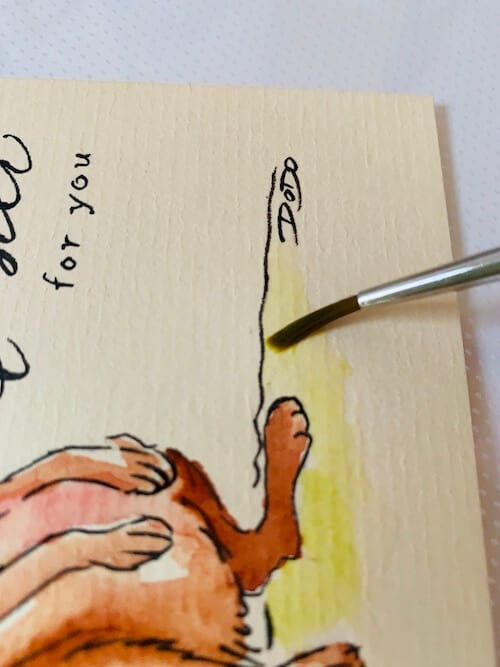 Du siehst, wie Dodo mit einem Aquarellpinsel Nr. 2 die grüne Wiese malt